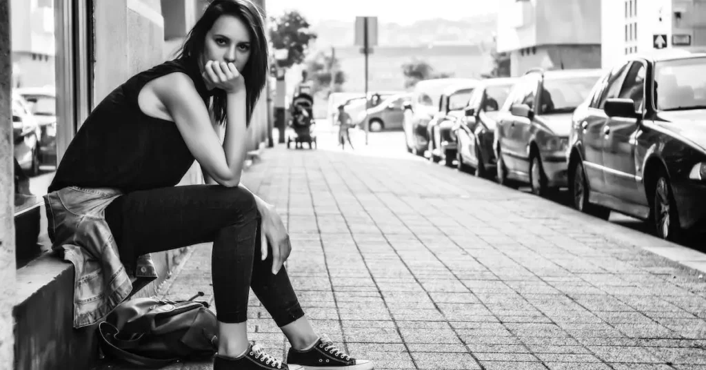 Female Pose Reference: A Guide to Capturing Feminine Forms 2024 108 woman sitting on the side of a street as a female pose reference
