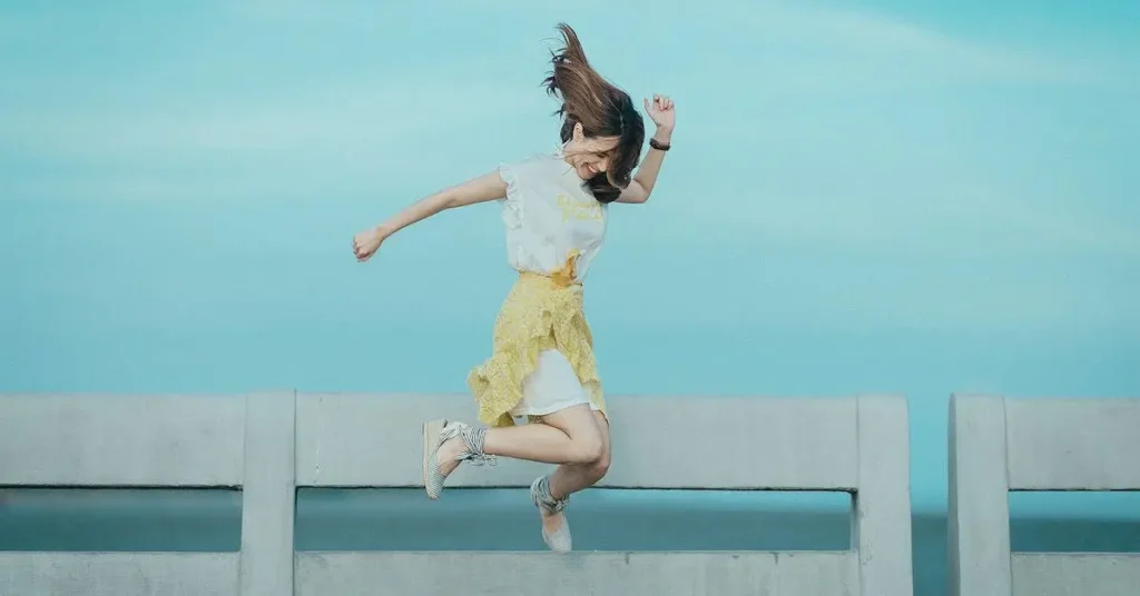 Female Pose Reference: A Guide to Capturing Feminine Forms 2024 112 woman jumping in front of the sky as a female pose reference