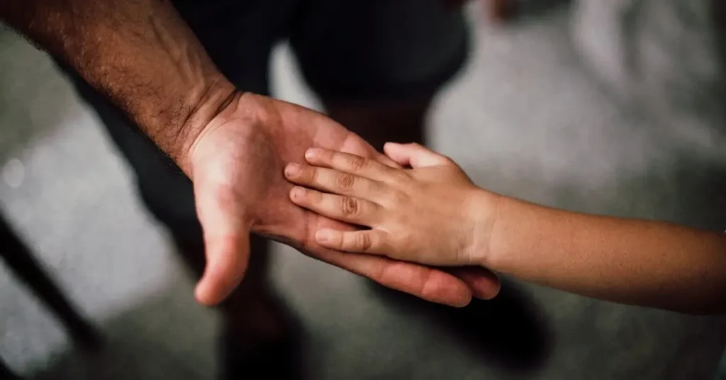 Father's Day Drawing Ideas: New Ways to Celebrate Your Dad 2024 3 a child placing her hand in a mans hand as Father's Day Drawing Ideas